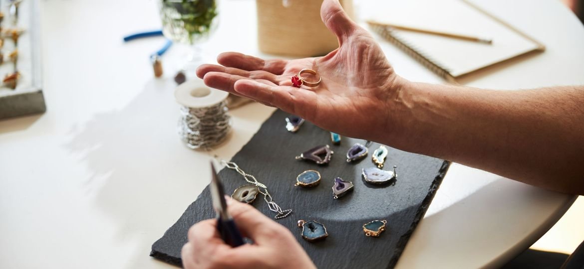 Professional jeweler holding his new jewelry item on his palm