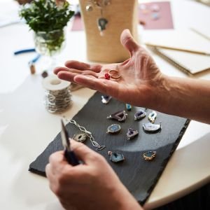 Professional jeweler holding his new jewelry item on his palm